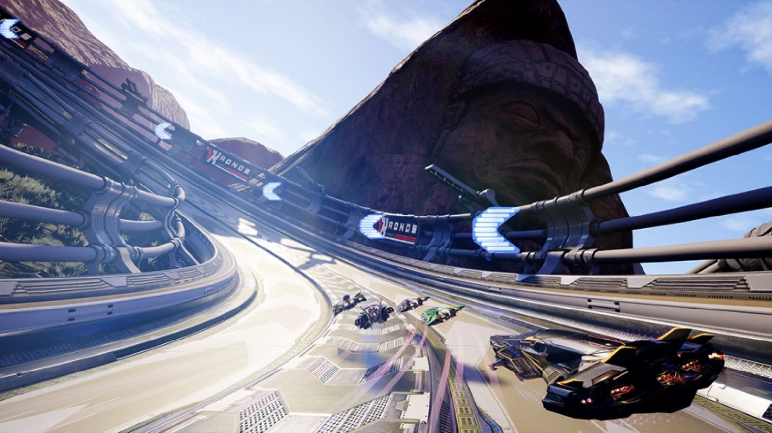 cars on a race track near a mountain with a face on it