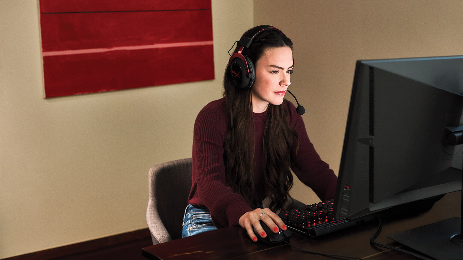 woman in front of a computer with a hyper x gaming headset on